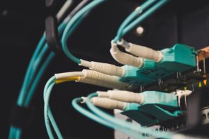 A close up of an ethernet cable connected to a computer used in network penetration testing.