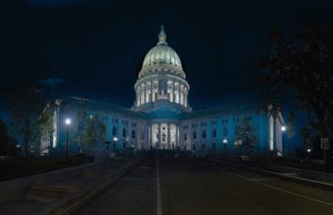 The state capitol building is lit up at night.