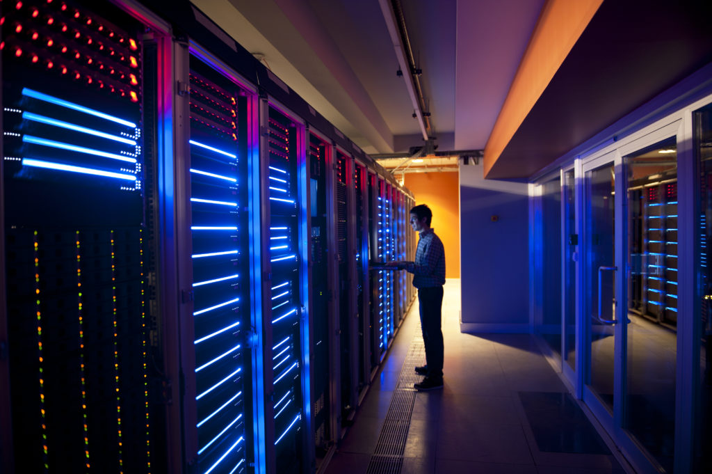 A MegaPlanIT employee working in a modern interior of server room in datacenter.