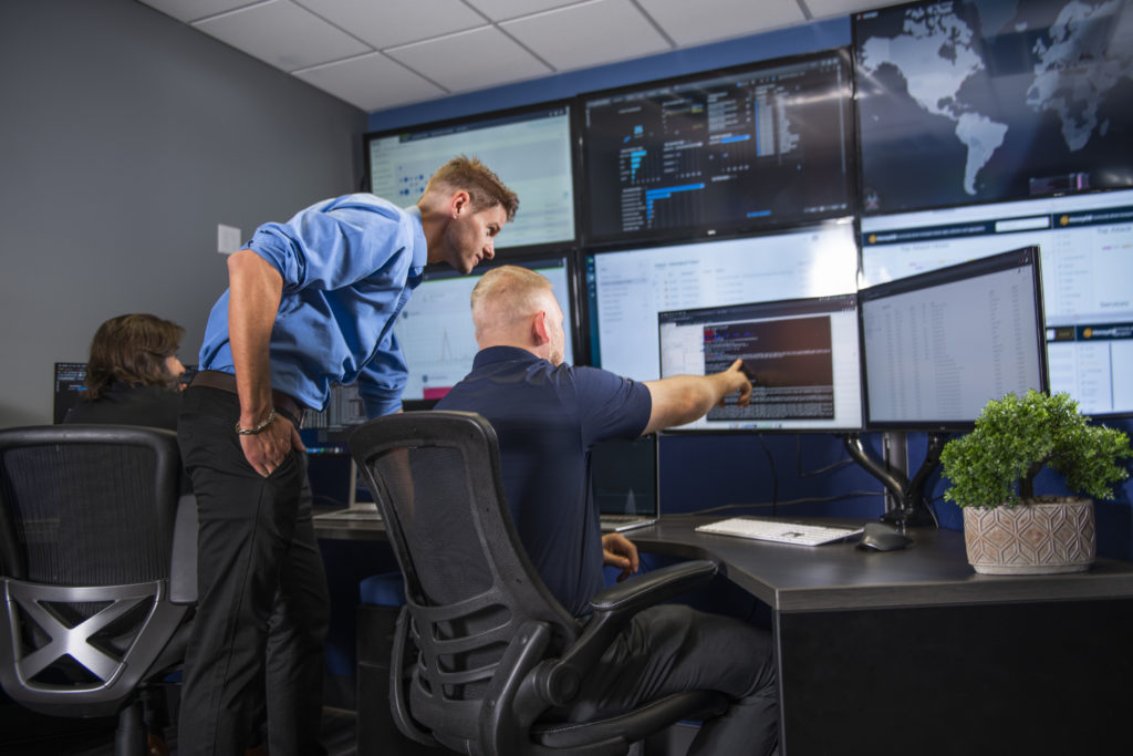 A group of people managing security in a control room.